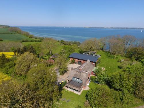 an aerial view of a house on a hill next to the water at Ostscheune am Mühlendamm in Steinbergkirche