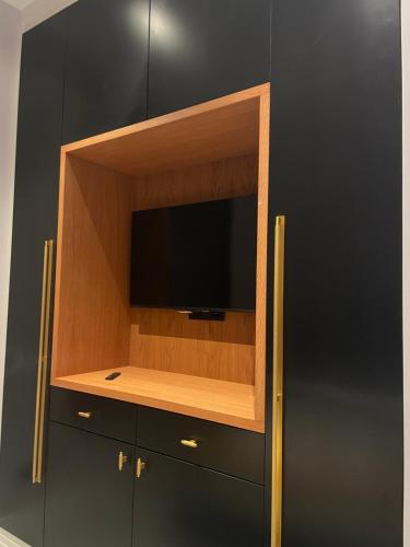 a entertainment center with a flat screen tv on a wall at Apartamentos Maguilla IV- Parking incluido para huéspedes in Badajoz