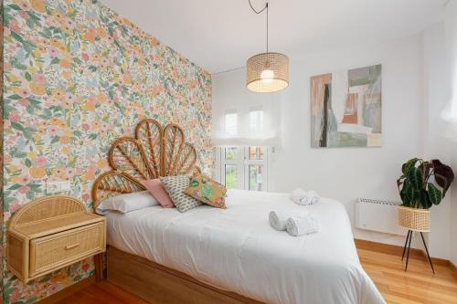 - une chambre avec un lit blanc et un papier peint floral dans l'établissement Playa y descanso con parking by CABANA Rentals, à Ribeira