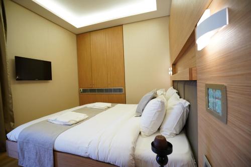 a bedroom with a large bed with white pillows at Heaven Prestige Hotel in Jounieh