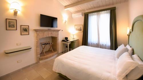 a bedroom with a white bed and a fireplace at Tenuta Ciminata Greco in Rossano