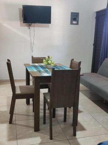 a dining room table with chairs and a television at Departamento Flor de María in Ciudad Madero