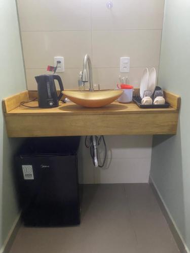 a wooden counter with a sink in a bathroom at Suíte 1 Praia do Grant in Barra Velha