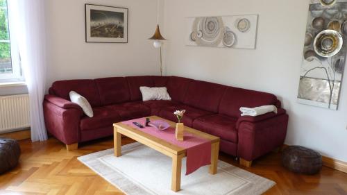a living room with a red couch and a coffee table at Apartment Kunsthaus Panorama 1 OG mit Balkon in Nordhausen
