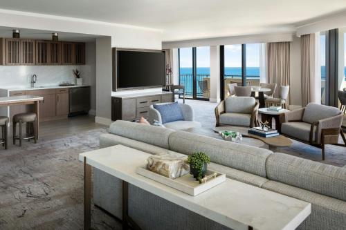 a living room with a couch and a tv at Fort Lauderdale Marriott Harbor Beach Resort & Spa in Fort Lauderdale