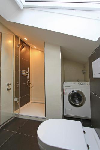 a bathroom with a toilet and a washing machine at Ferienwohnung am Harz in Seesen