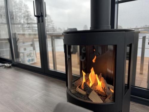 einen Kamin mit Kamin neben einem Fenster in der Unterkunft Hausboot Bakerman in Zehdenick