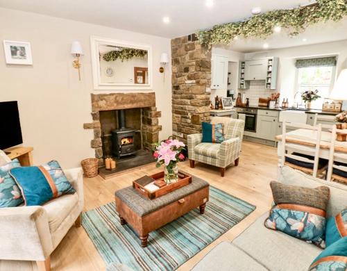 a living room with a couch and a fireplace at River Dance Cottage, Aysgarth in Aysgarth