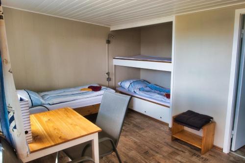 a small room with two bunk beds and a table at Finnenhaus 6 in Lübeck