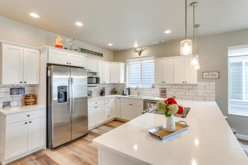 a kitchen with white cabinets and a stainless steel refrigerator at Spacious, Rustic Spearfish Home Walk to Downtown! in Spearfish