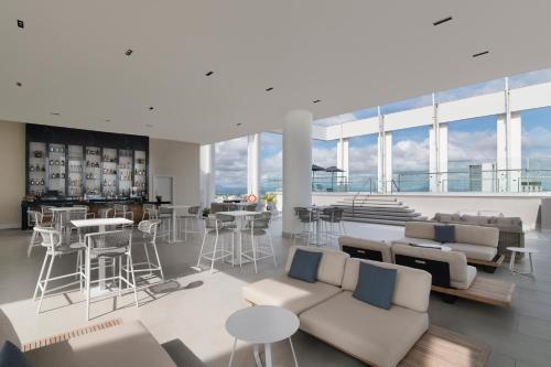 a living room with white furniture and large windows at Hyatt Centric Santo Domingo in Santo Domingo