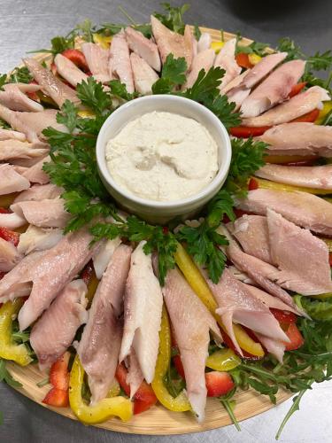 a plate of meat and vegetables with a dipping sauce at Tawerna Pod Kotwicą pokoje i domy wakacyjne in Kadłub Wolny