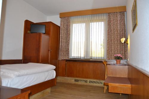 a hotel room with a bed and a window at Top Hotel Garni, Modus Hotelbetriebe GmbH in Dormagen