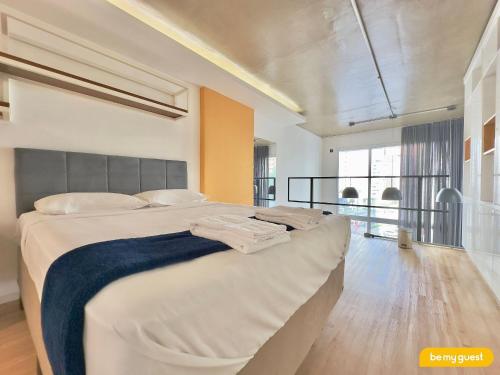 a bedroom with a large bed with a blue blanket at Loft Praia - Meireles in Fortaleza
