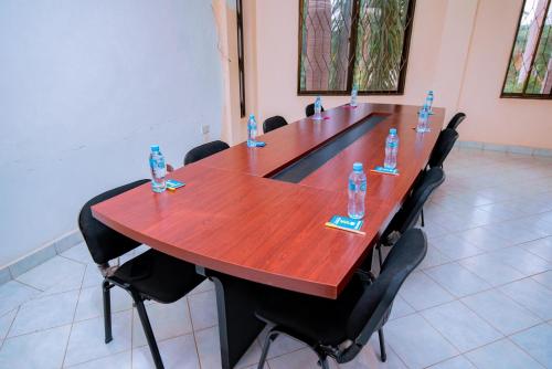 a long wooden table with bottles of water on it at WILIVINA HOTEL in Dar es Salaam