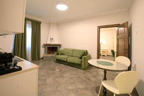 a living room with a green couch and a table at Tenuta Ciminata Greco in Rossano