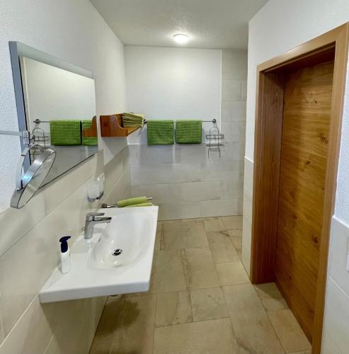 a bathroom with a sink and a mirror at Haus Sonnentau Wohnung 1 in Kißlegg