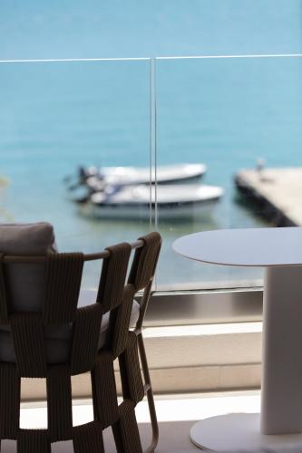 a table and two chairs next to a table and a window at Naiades Boutique Hotel - Adults Only in Elounda