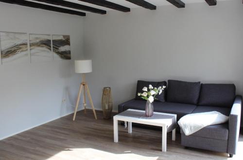a living room with a black couch and a table at Ferienhaus Strandnah - Wohnung 1 in Otterndorf