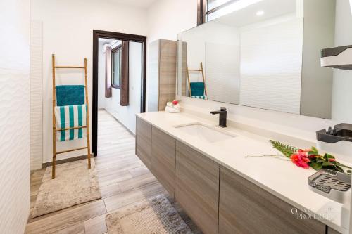 a bathroom with a sink and a mirror at Villa Tehani - 3BR Beachfront Villa in Hauru