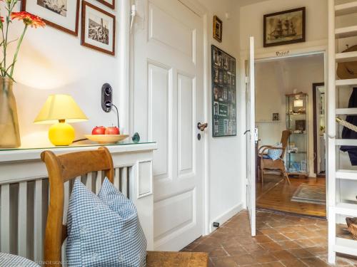 pasillo con puerta y mesa con lámpara en altes Kapitänshäuschen, en Prerow