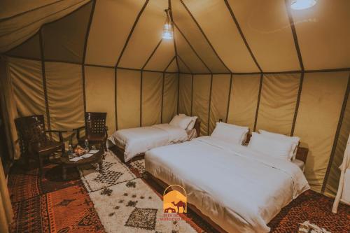 a bedroom with two beds in a tent at Trek desert Morocco Sarl in Taouz