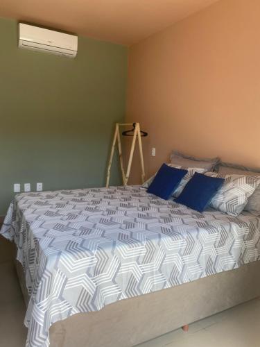 a bedroom with a large bed with blue pillows at Suíte 2 Praia do Grant in Barra Velha