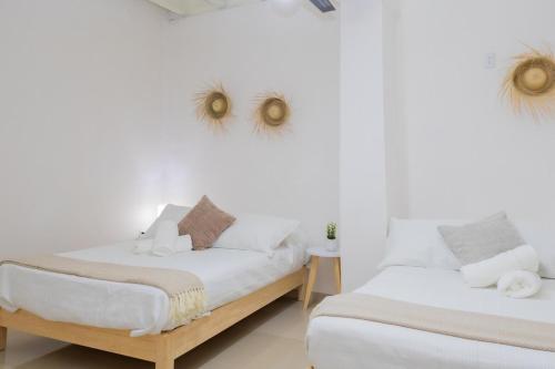 twee bedden in een kamer met witte muren bij NEW! Aldea Bamboo 3 Terrace & Centro in Cuernavaca