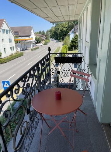 a table on a balcony with a red cup on it at Grosse Neue Wohnung in Bern mit Whirlpool in Bern