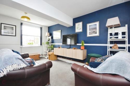 a living room with two couches and a blue wall at Dog friendly Beach Apartment in Broadstairs