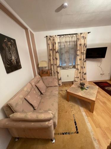 a living room with a couch and a table at Schöne Ferienwohnung in Bahnhofsnähe für Urlaub, Studium oder Arbeit in Deggendorf