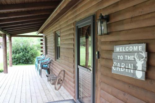 una señal en el lateral de un edificio con una puerta al patio de fiestas en Bushwood Cabin, en Logan