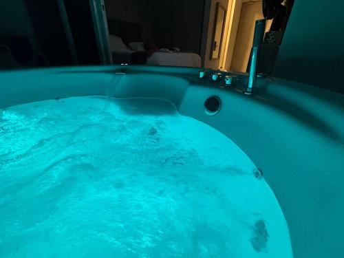 a bath tub with blue water in a bathroom at Suite con Lujoso Jacuzzi, Piso 14 y vista al mar in Santa Marta