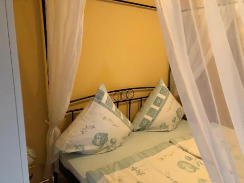 a bed with white curtains and pillows on it at Schöne Ferienwohnung in Bahnhofsnähe für Urlaub, Studium oder Arbeit in Deggendorf