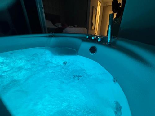 a bath tub with blue water in a bathroom at Suite con Lujoso Jacuzzi, Piso 14 y vista al mar in Santa Marta