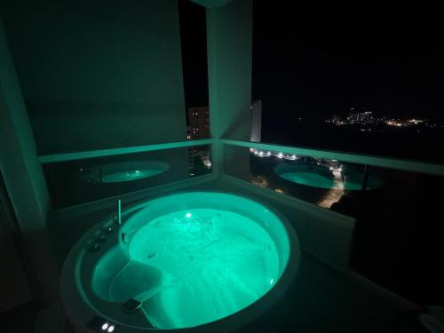 a bathroom with two sinks and a green tub at Suite con Lujoso Jacuzzi, Piso 14 y vista al mar in Santa Marta