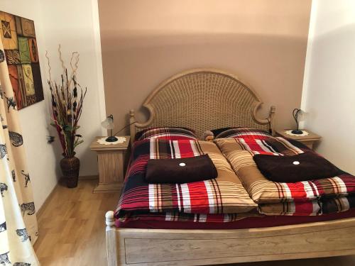 a bed with a plaid blanket and pillows on it at Schöne Ferienwohnung in Bahnhofsnähe für Urlaub, Studium oder Arbeit in Deggendorf