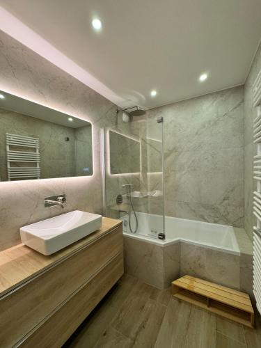 une salle de bain avec un lavabo, une douche et une baignoire dans l'établissement appartement spacieux, à Clichy