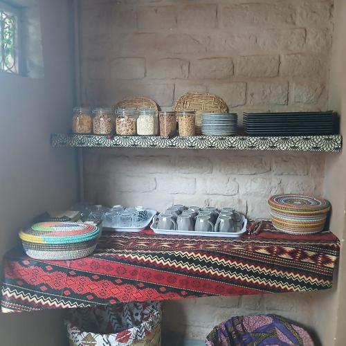 a shelf with plates and bowls and dishes on it at "Par 4 chemins" Atypical Stopover in Nouakchott