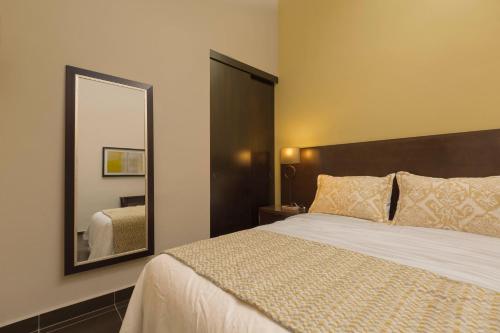 a bedroom with a large bed and a mirror at Decanter Hotel in San Juan