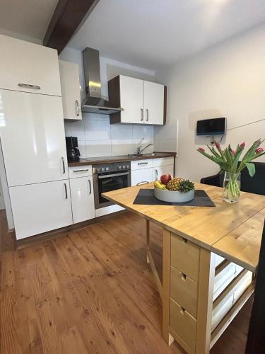 a kitchen with a table with a bowl of fruit on it at Ferienwohnung Ost in Fehmarn