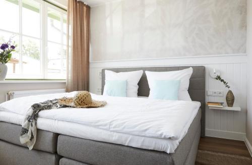 Schlafzimmer mit einem Bett mit weißer Bettwäsche und blauen Kissen in der Unterkunft Villa Fortuna - Suite mit Terrasse in Ostseebad Sellin