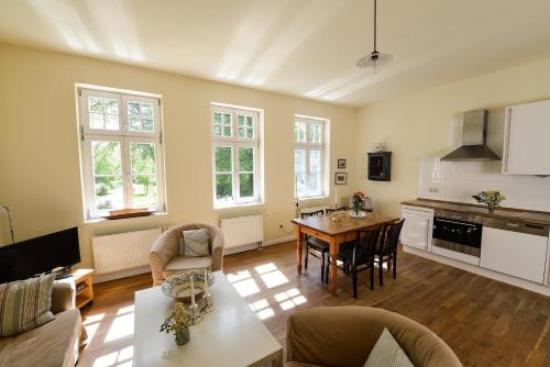 NeuenkirchenFerienwohnung 2 mit schönem Seeblick的配有桌椅的厨房和客厅