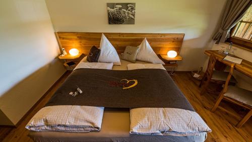 a large bed in a room with two lamps at Gästehaus Holzer Kreuz - Gästezimmer Veilchen für 2 Personen inkl Landfrühstück in Fröhnd