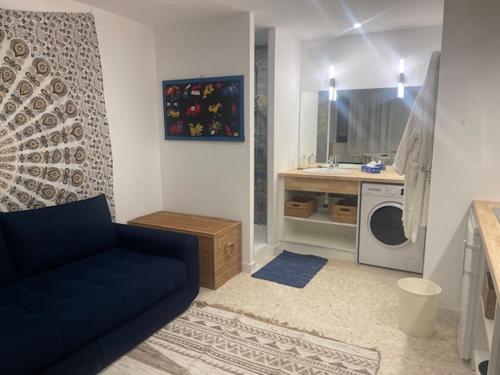 un salon avec un canapé bleu et une cuisine dans l'établissement ULYSSE, à Canet