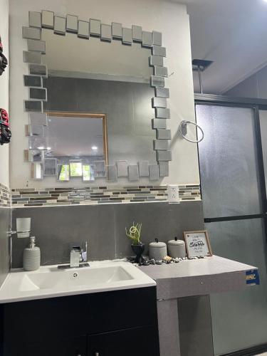 a bathroom with a sink and a mirror at Estudio con funciones inteligentes AC full moderno in San Salvador