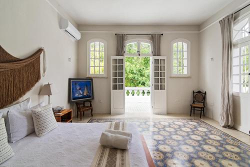a large bedroom with a large bed and windows at Casa Damiana in Mérida