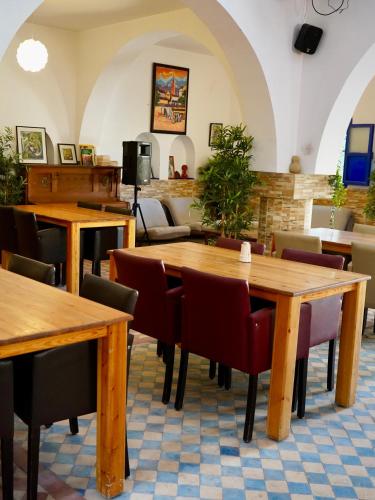 a restaurant with wooden tables and chairs at Tasra Surf Paradise, Imsouane in Imsouane