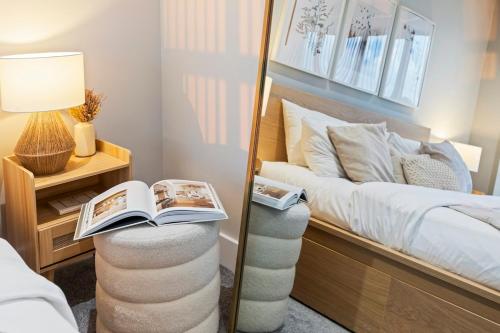 a bedroom with a bed with a mirror and a book at Beautiful Apartment in City Centre with Free Parking, Self-Check-In, Fast WiFi, Smart TV and Rooftop Terrace by Yoko Property in Leicester