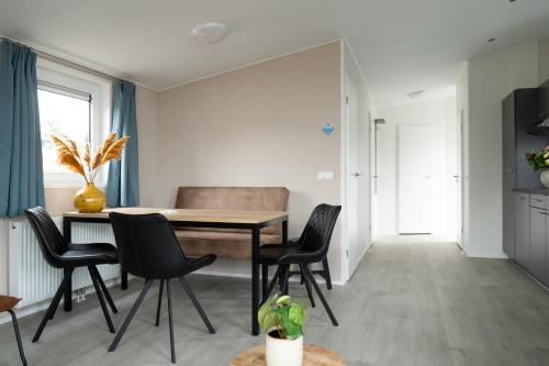 eine Küche und ein Esszimmer mit Tisch und Stühlen in der Unterkunft Chalet bis sechs Personen ohne Hund - a61179 in Norden